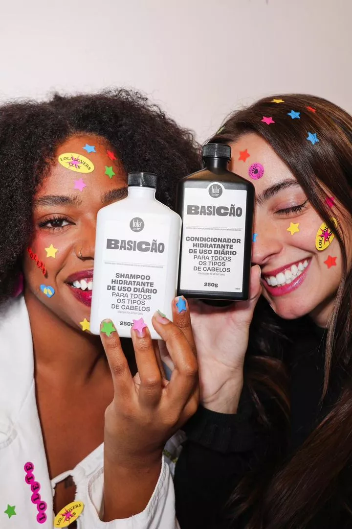 Duas pessoas segurando os produtos Basicão da Lola