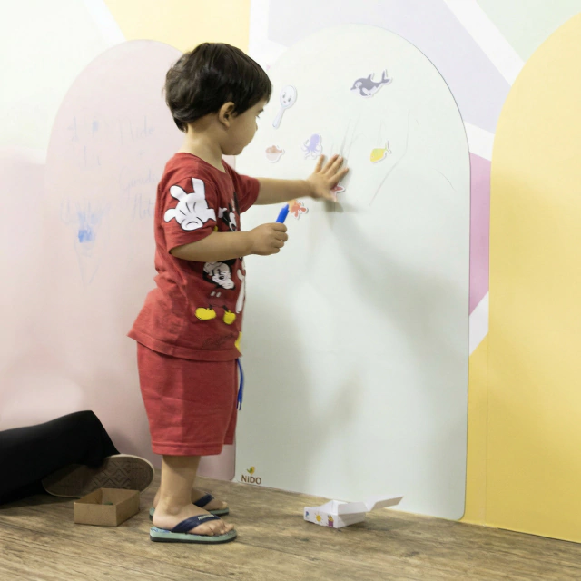 Menino desenhando na lousa magnética Nido verde