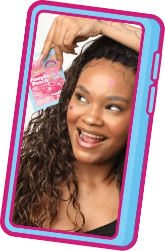 Jovem sorridente com adesivos coloridos no rosto segurando um sachê de Pimple Patch, dentro de um mockup de celular azul
