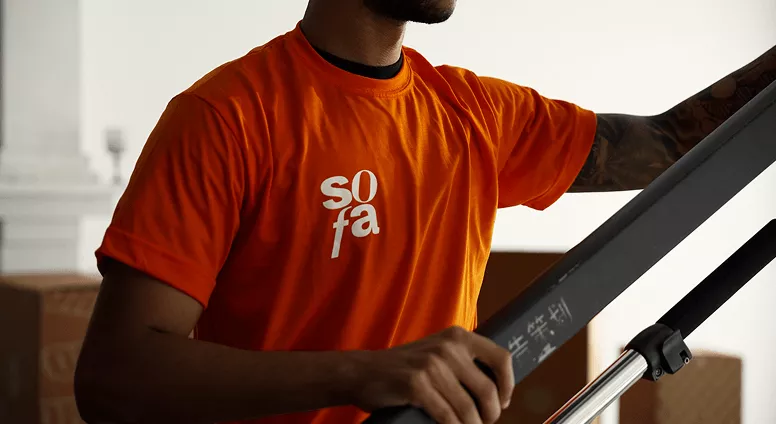 Homem com camiseta da Sofá na Caixa