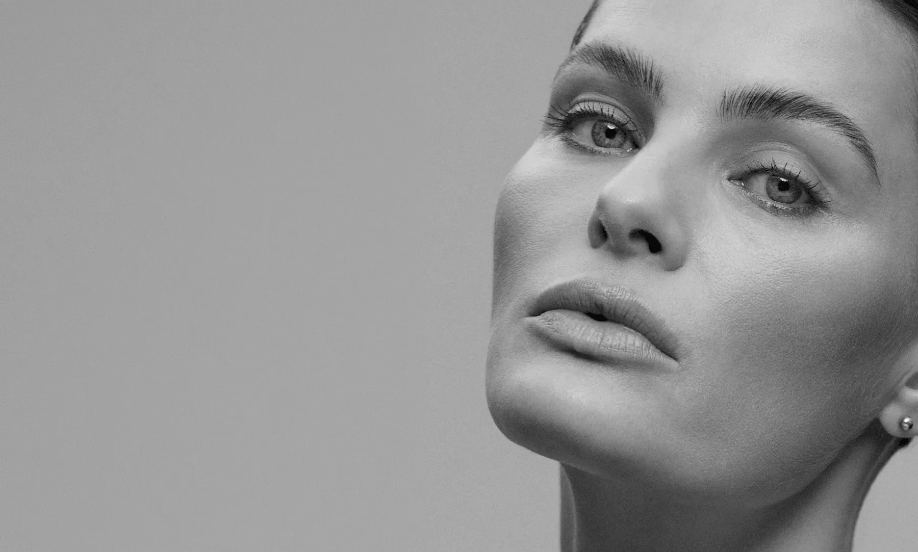 Retrato em preto e branco do rosto de uma mulher com pele natural e saudável